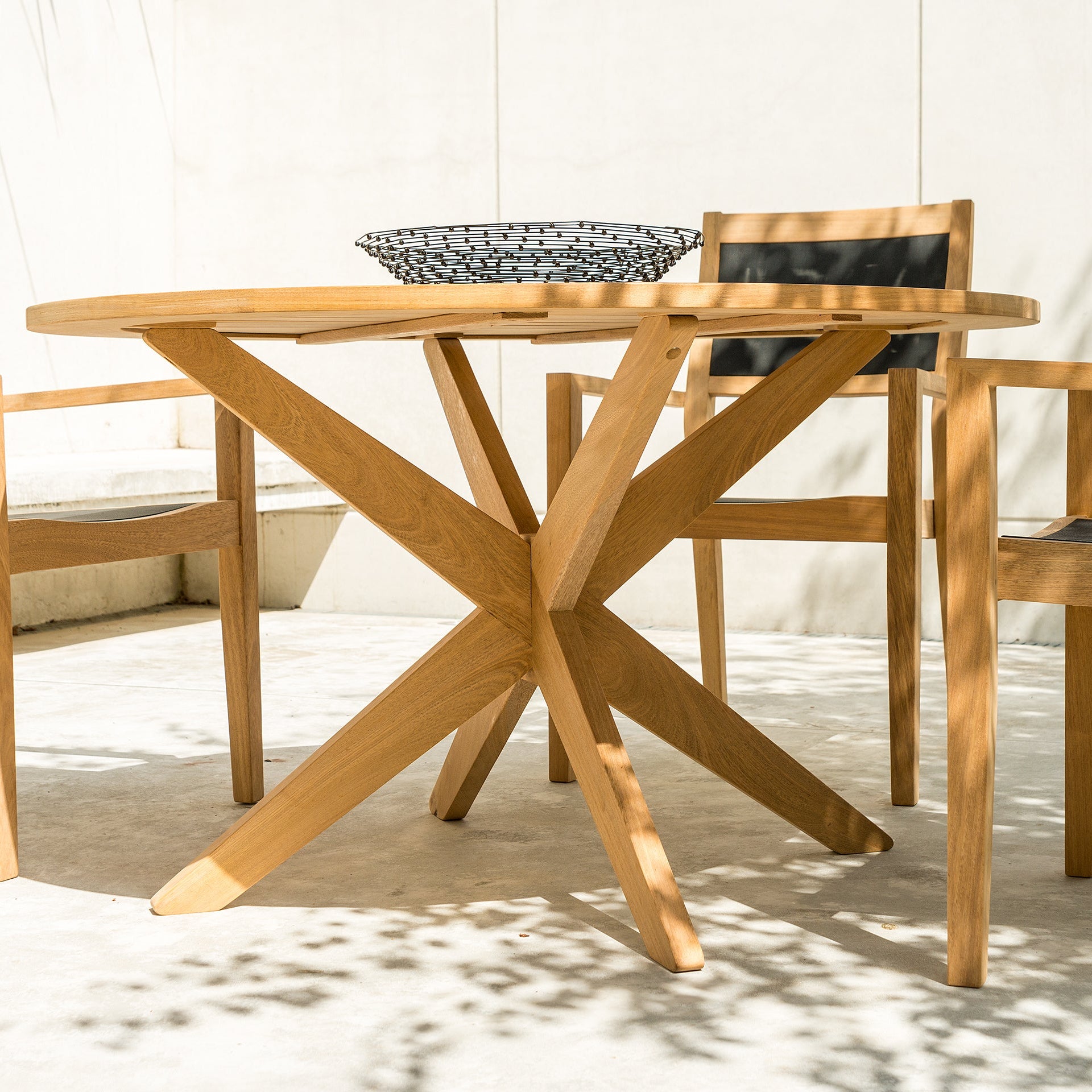 Roble outdoor round dining table with chairs on a patio