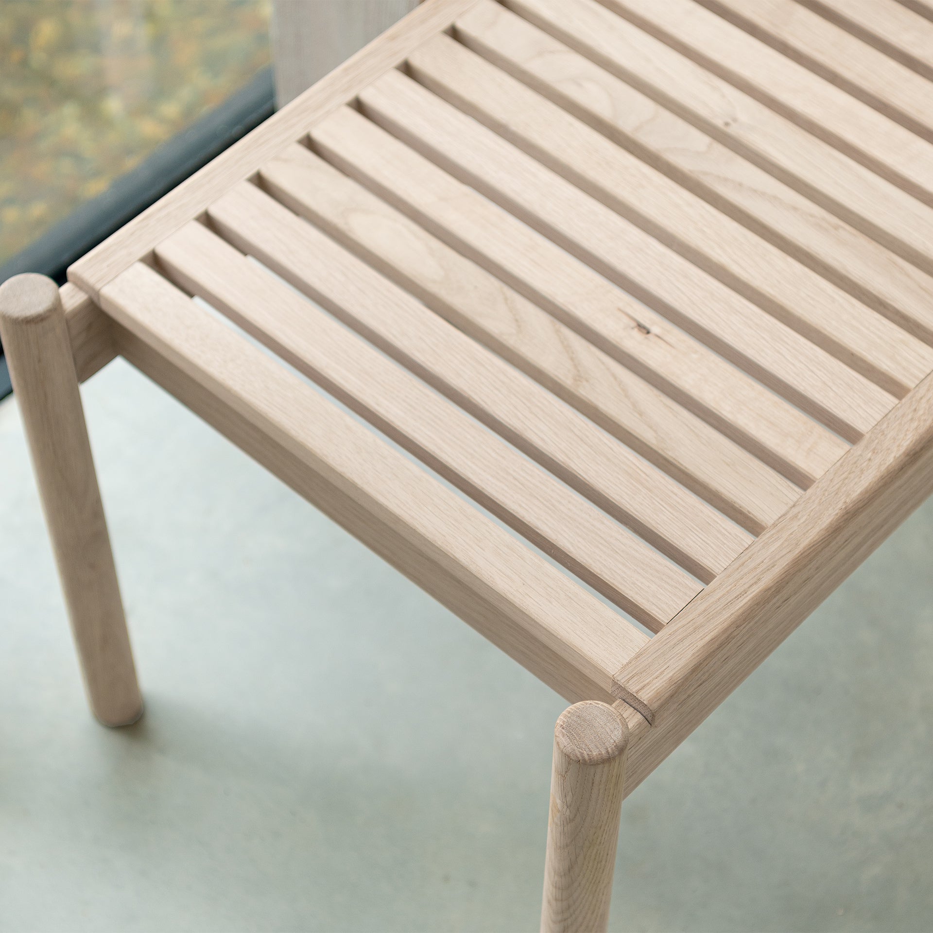 Looking down on the detail of the slatted indoor bench of light oak
