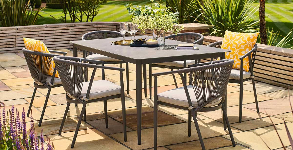 Aluminium 6-seater garden table and chairs in dark grey on a patio
