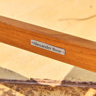 Wooden product with 'Alexander Rose' label on a blurred natural background