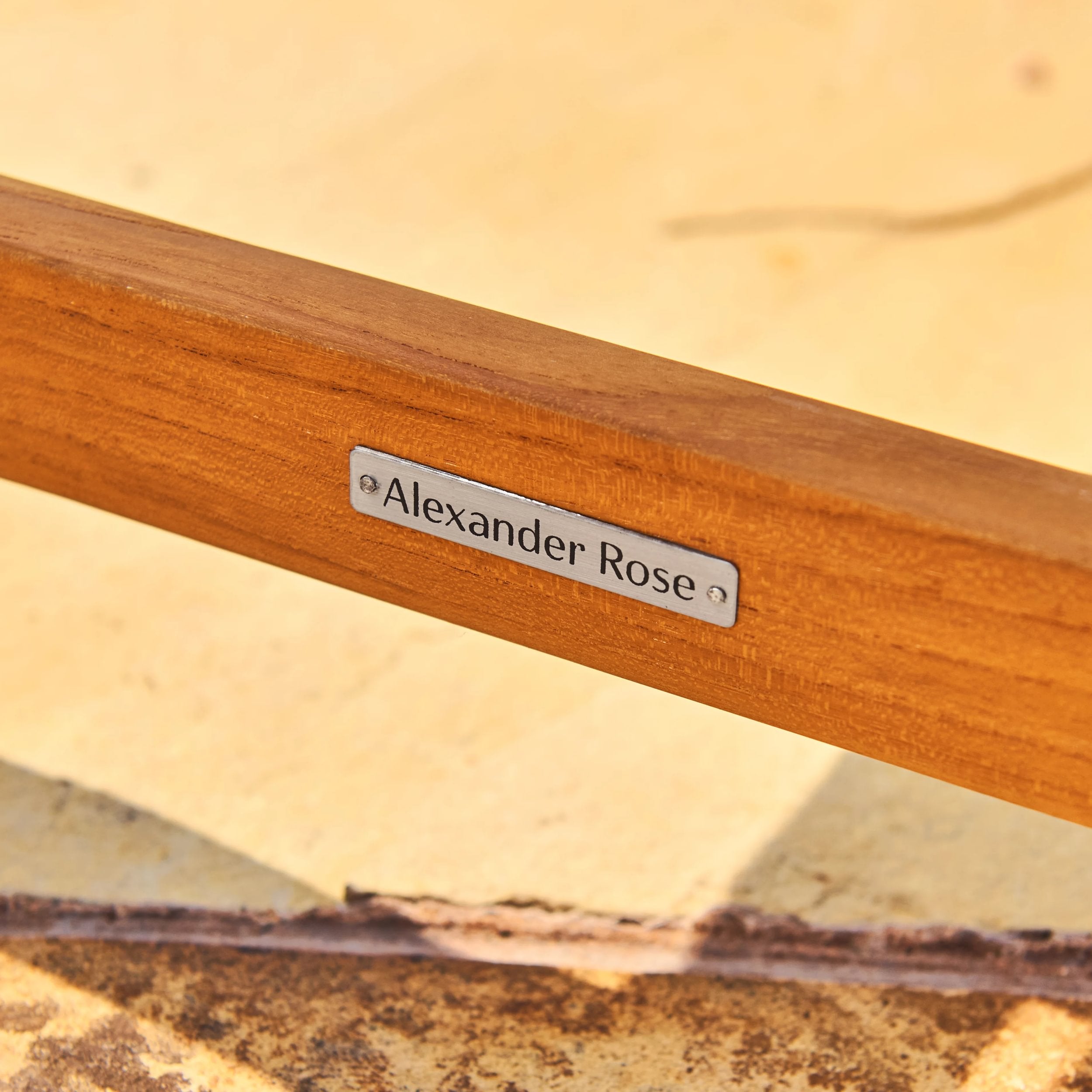 Wooden product with 'Alexander Rose' label on a blurred natural background