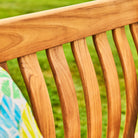 Close-up of a wooden bench with a blurred green background