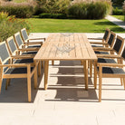 Extended roble dining table with 8 chairs positioned equally on either side on a patio area