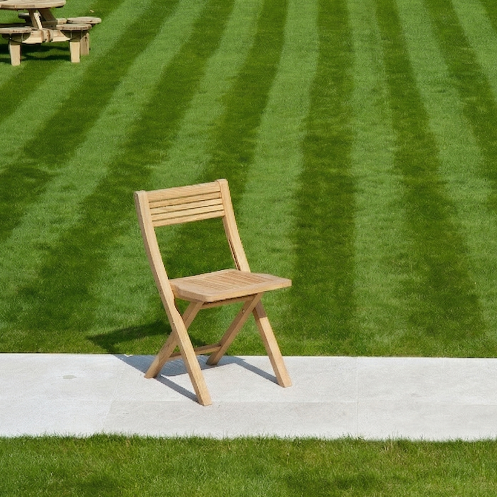 one folding chair on a path with lawn background