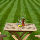 slatted wooden folding table with drinks and fruit on a grassy background