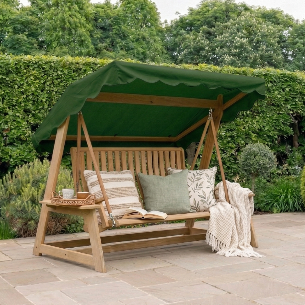 Wood swing seat with green canopy, cushions and blanket draped over the seat