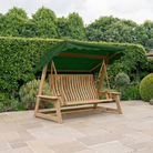 luxury wood swing seat with green canopy on a patio with hedge and green plants