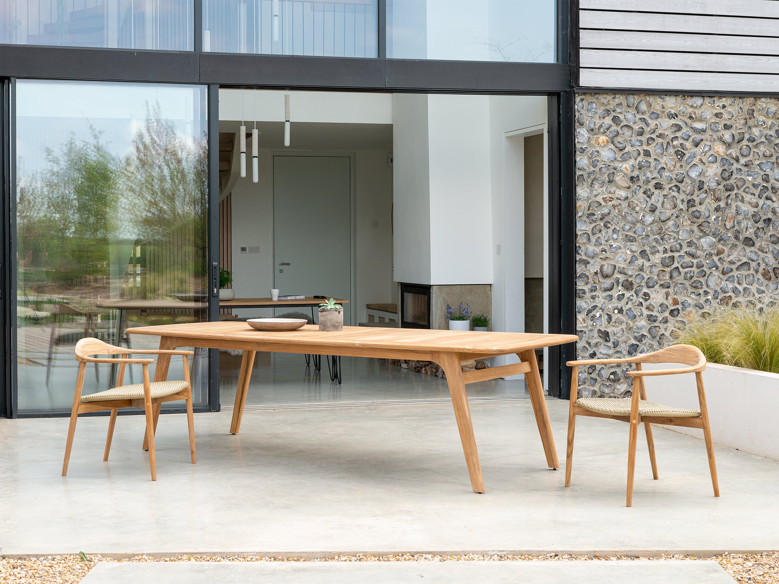 Large stylish wooden dining table with chairs on a patio