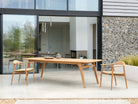 Large stylish wooden dining table with chairs on a patio