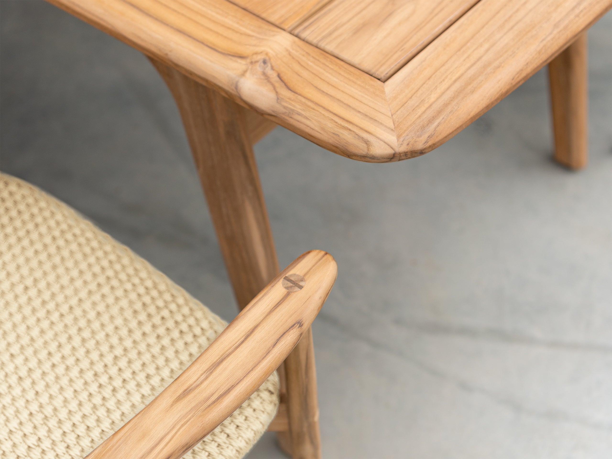 Close-up of a wooden chair with a woven seat on a neutral background