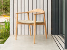 Curved outdoor armchair beautifully styled with woven seat pad