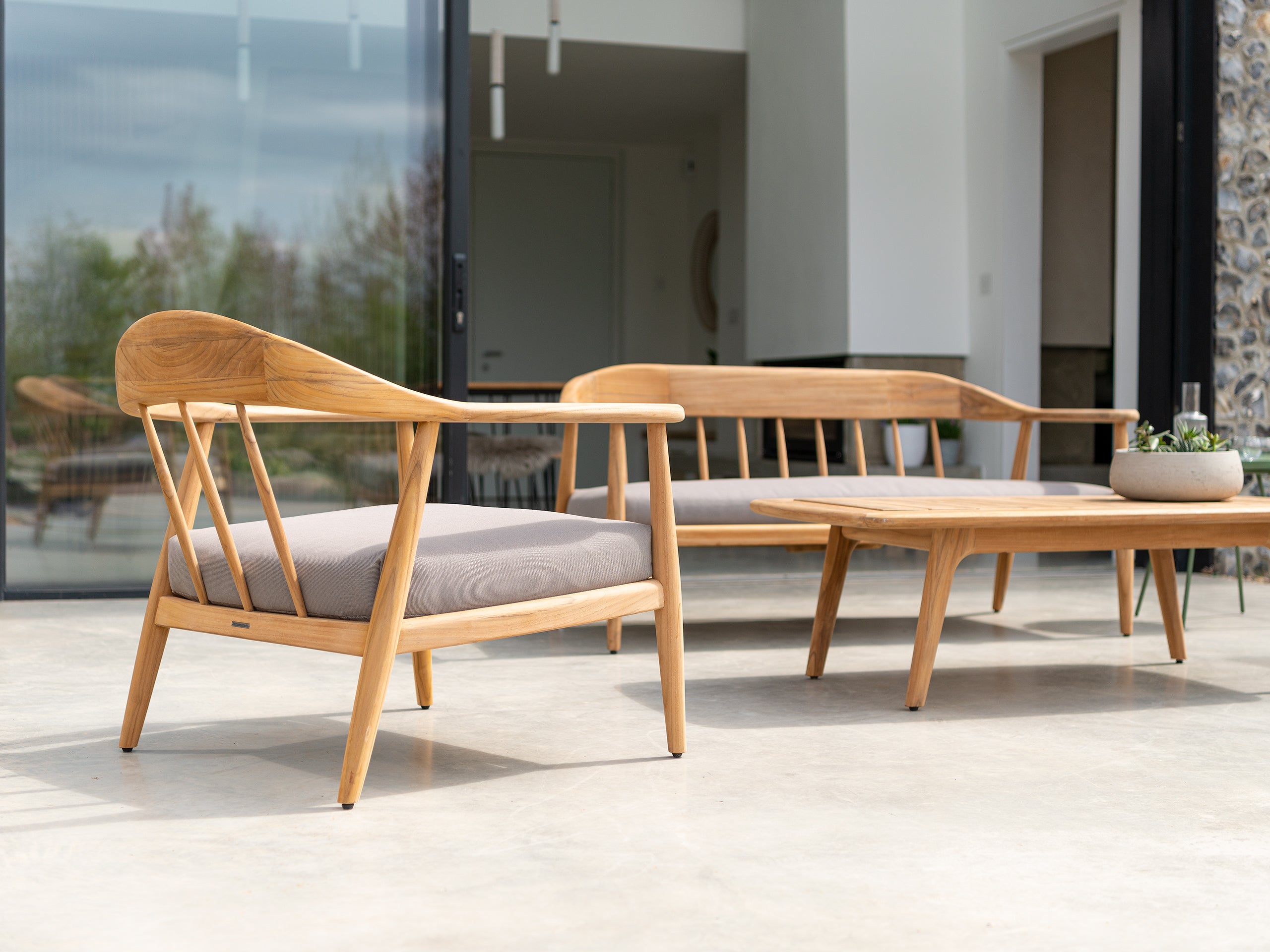 Teak outdoor lounge set with beautiful features, curved backs and grey seat covers