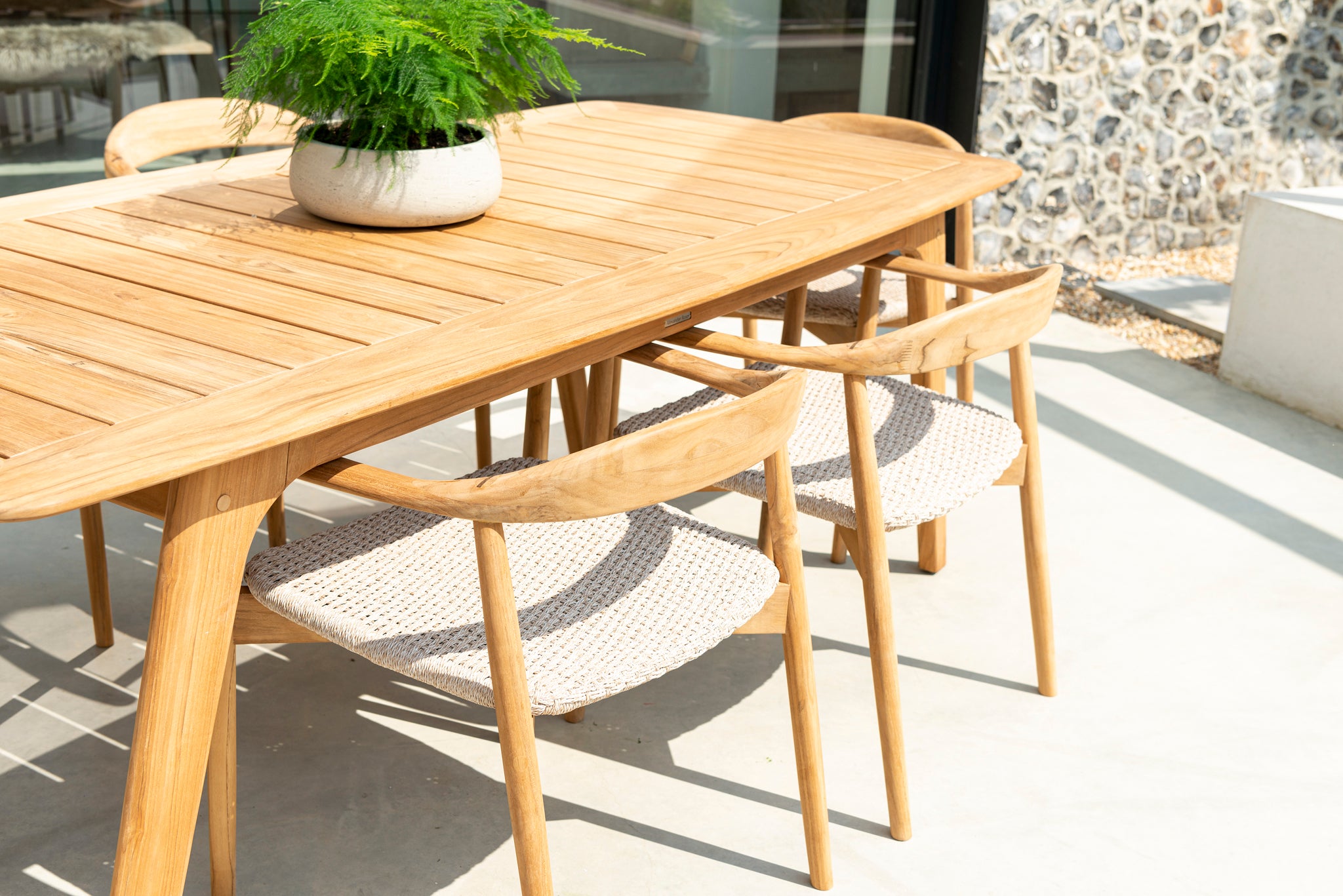 Wooden outdoor dining table with chairs on a patio