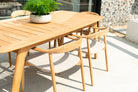 Wooden outdoor dining table with chairs on a patio