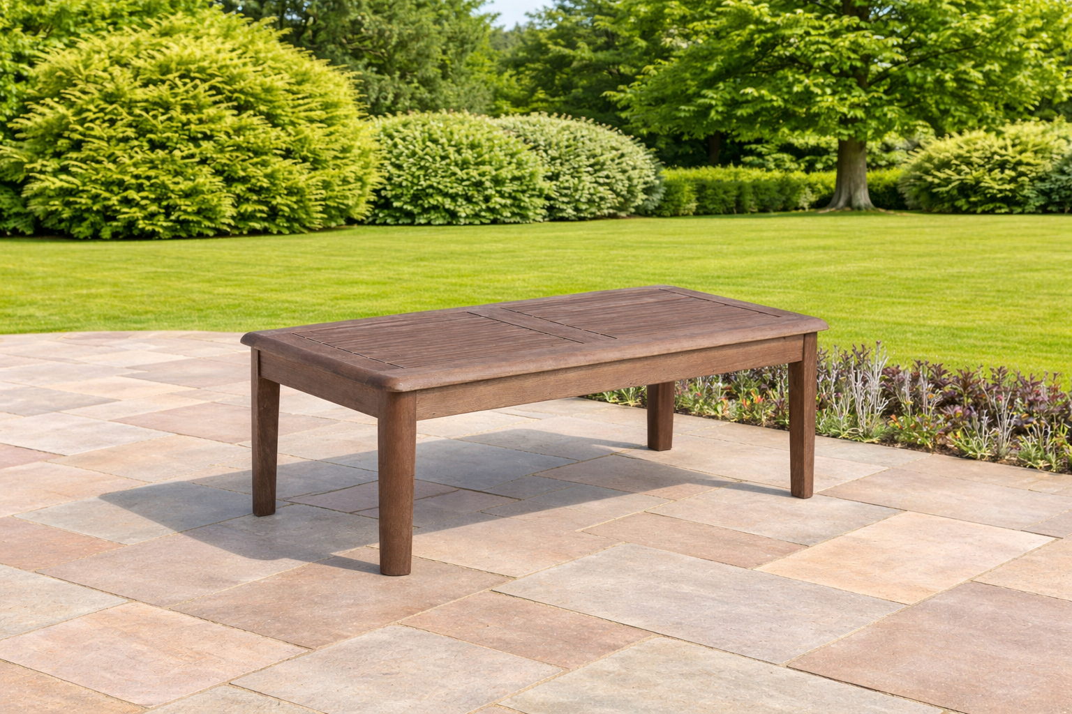 Wooden outdoor table on a patio with greenery in the background
