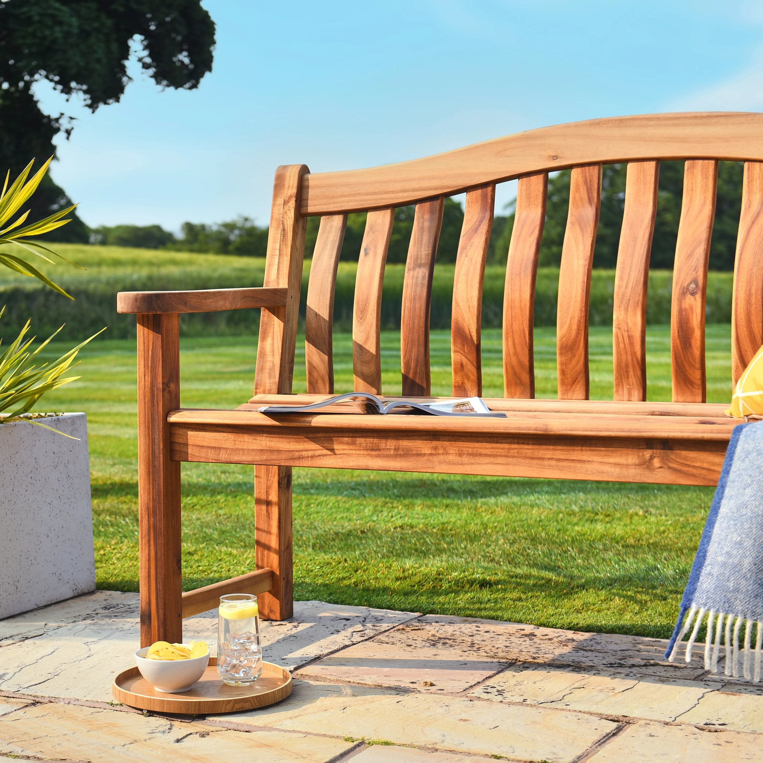 Wooden bench in a garden with a clear blue sky
