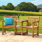 Wooden outdoor furniture set with a bench and chairs on a patio, featuring a blue cushion and a bottle of water.