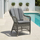 Monte Carlo open weave armchair on a terrace beside a swimming pool under natural daylight.
