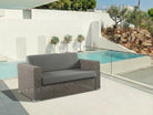 Grey outdoor 2-seater sofa with by a poolside