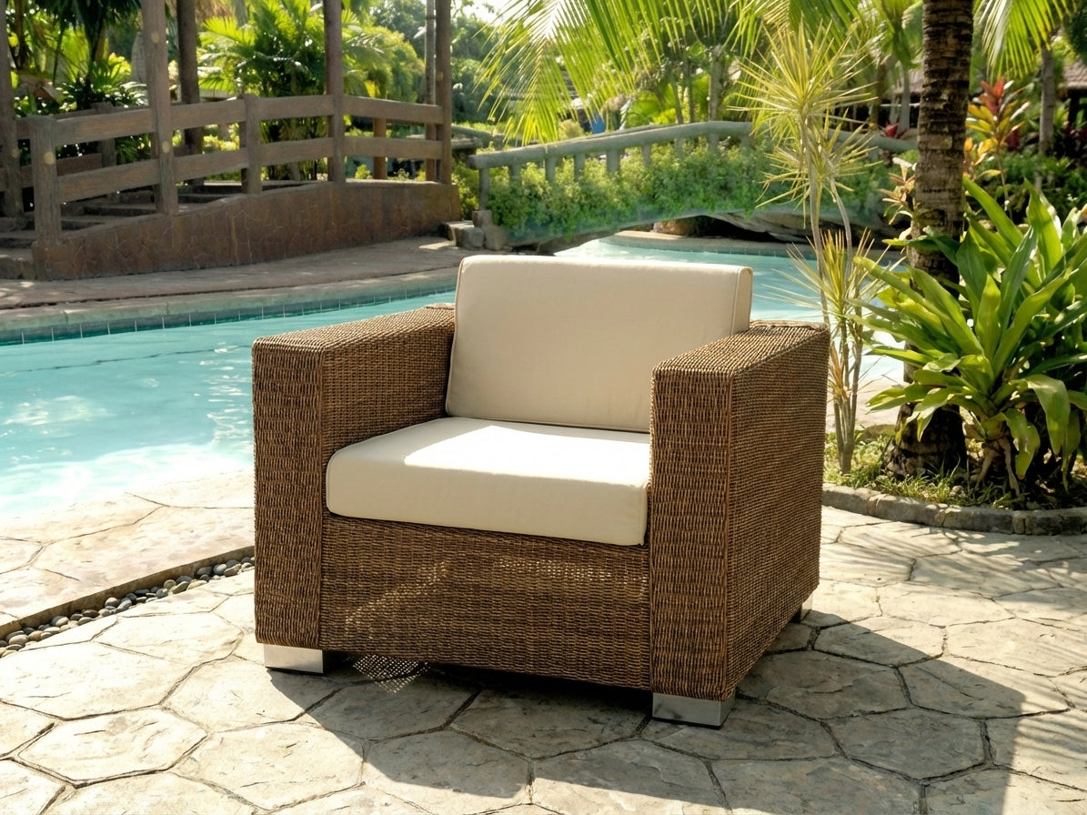 Luxury rattan chair with beige cushions by a poolside in a garden setting