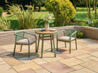 Outdoor patio bistro set with a round table and two chairs on a stone patio.