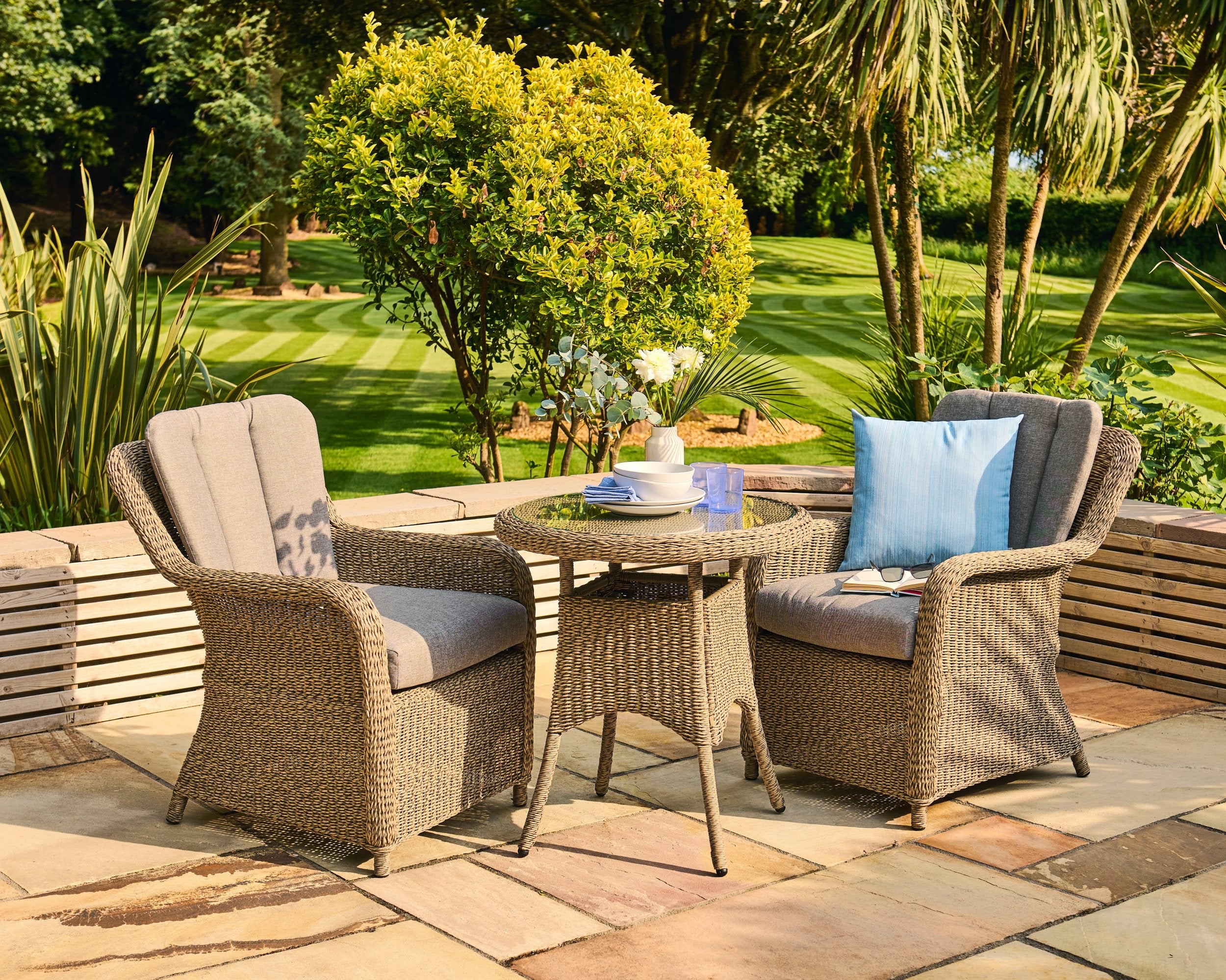 Wicker outdoor furniture set with cushions on a patio