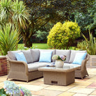 Outdoor patio set with a sectional sofa and coffee table in a garden setting.