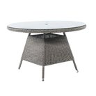 Round outdoor dining table with wicker frame and glass top on a white background