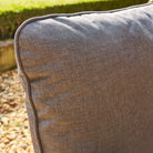 Close-up of a textured grey cushion on a garden bench.