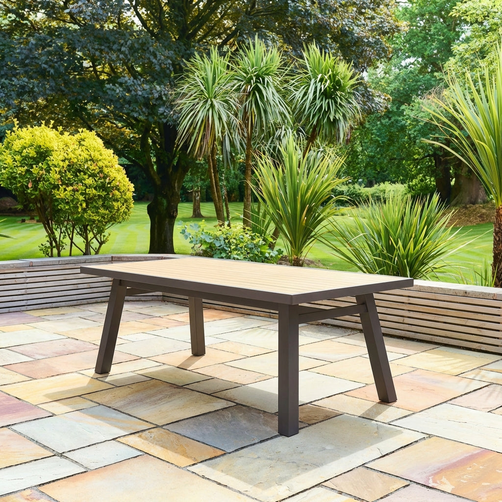 Outdoor patio table on a stone patio with greenery in the background