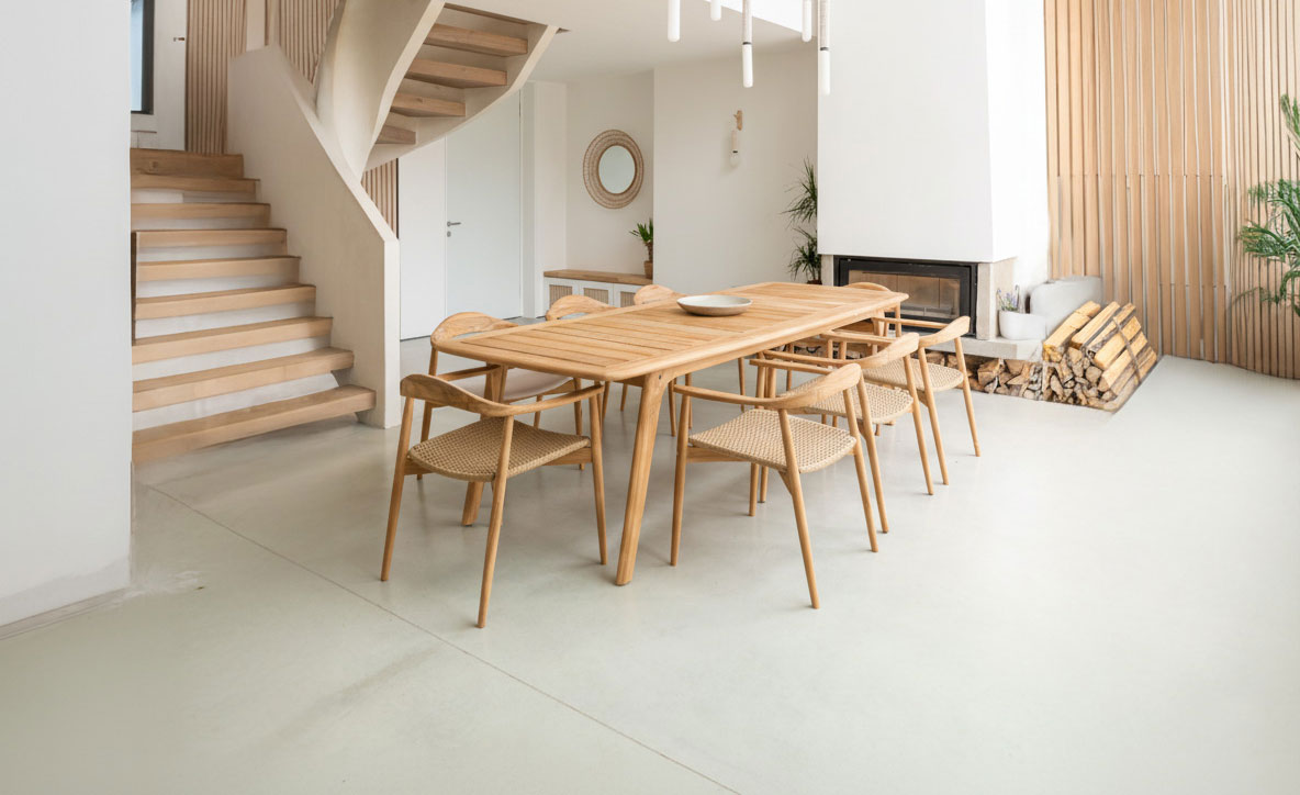 large indoor dining table with 8 chairs. These are Danish in design with curved light wood arms. 