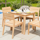 Wooden outdoor dining set with table and chairs on a patio near a pool.