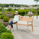 woman on a roble bench reading a newspaper