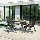 Outdoor dining set with table and chairs on a wooden deck.