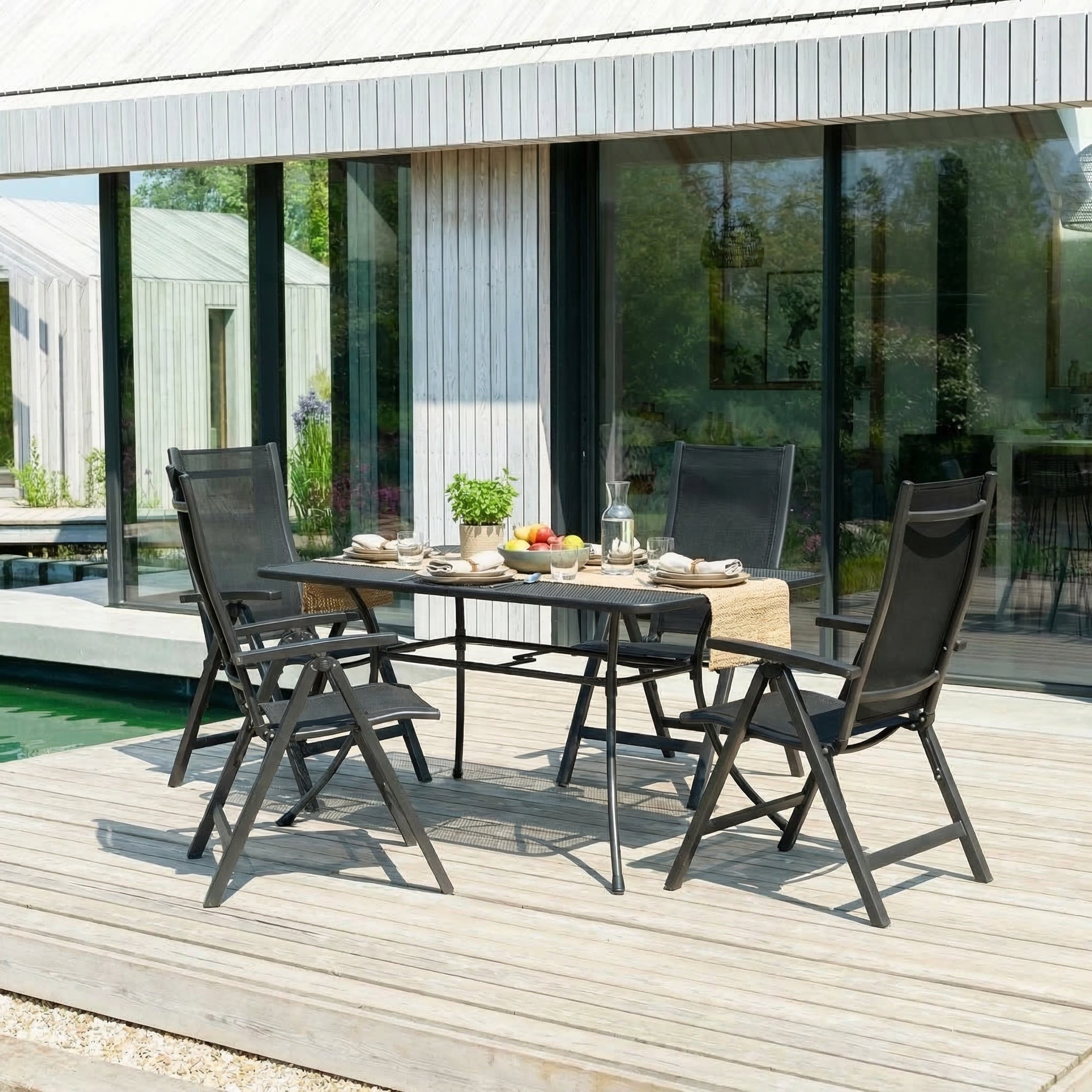Outdoor dining set with table and chairs on a wooden deck.