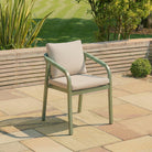 Green outdoor chair with beige cushions on a patio