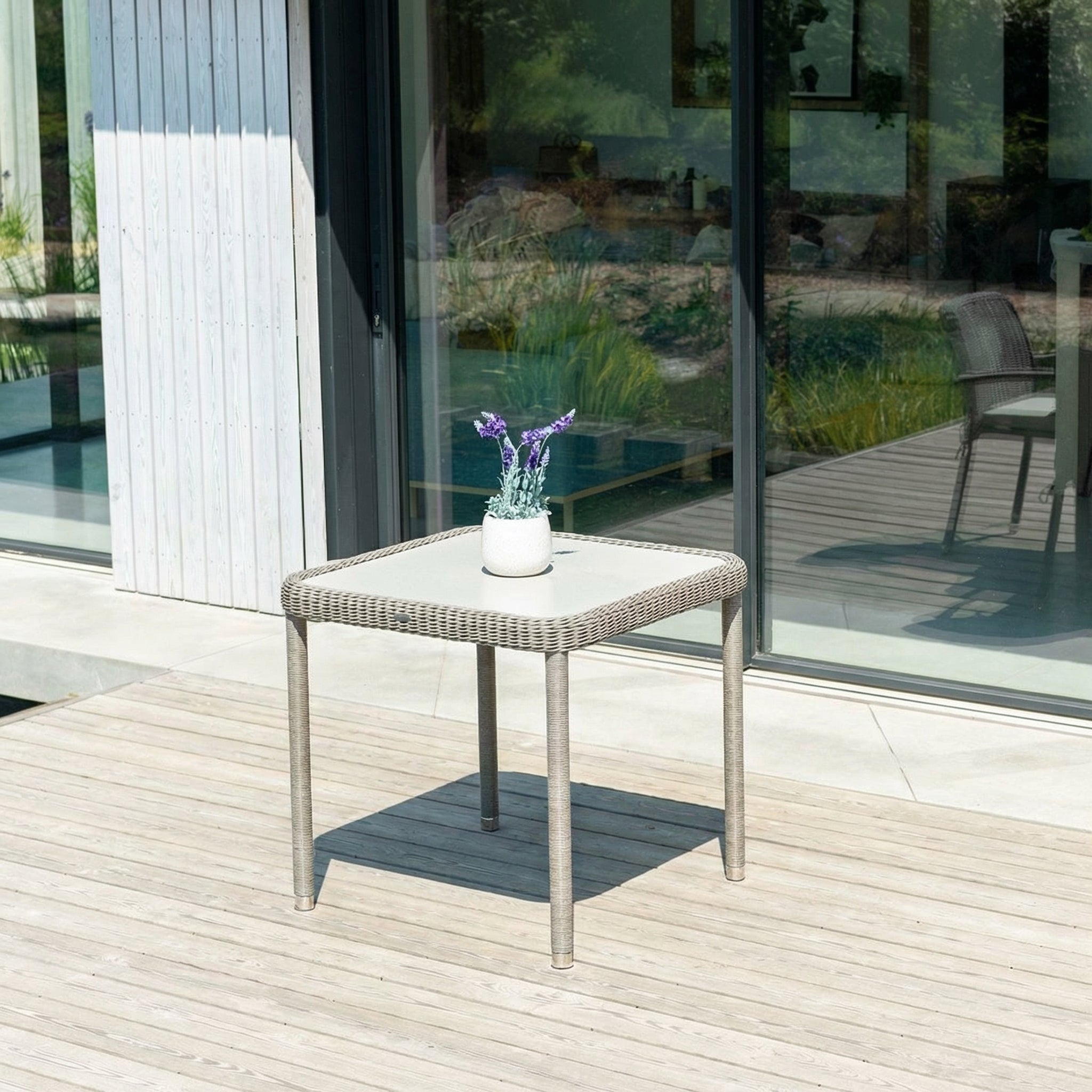 Small outdoor table with a plant on a wooden deck