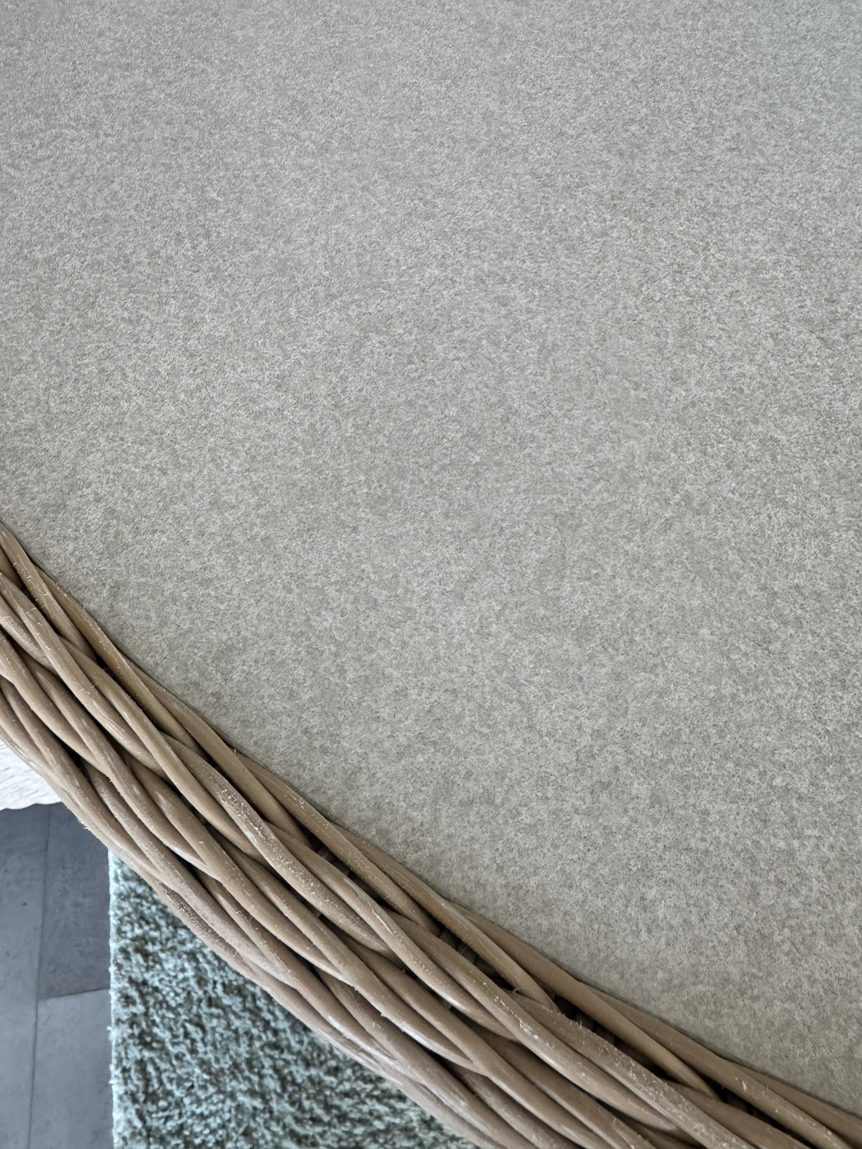 close up of rattan table edge in light grey