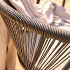 Close-up of a grey rope chair with a blurred background