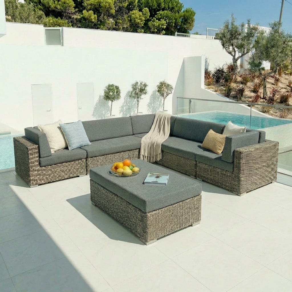 Outdoor patio furniture set with a sectional sofa and an ottoman by a pool.