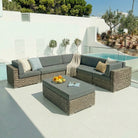 Outdoor patio furniture set with a sectional sofa and an ottoman by a pool.