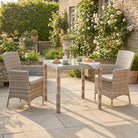 Outdoor patio set with wicker chairs and table in a garden setting
