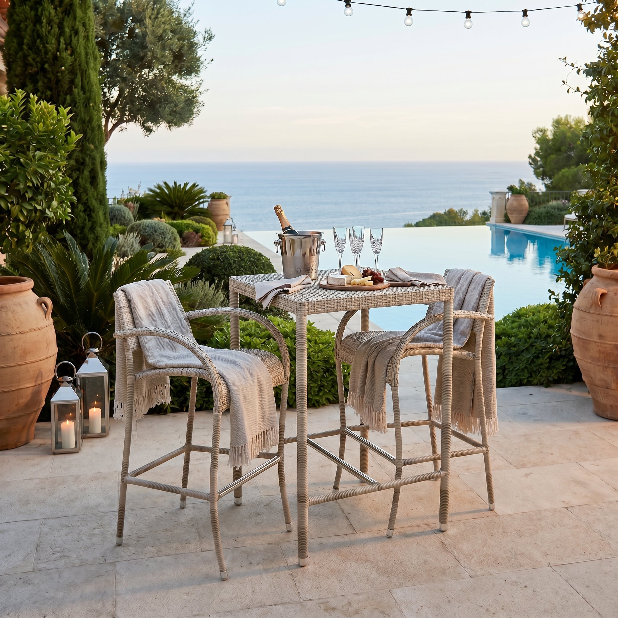 Outdoor patio setting with high chairs, table, and ocean view.