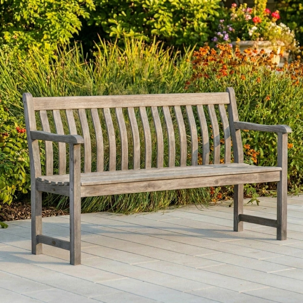 Wooden bench on a wooden deck with greenery and flowers in the background