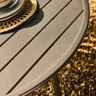Round outdoor table with a textured surface on a gravelly ground