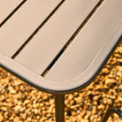 Close-up of a metal outdoor table with a blurred natural background