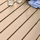 Close-up of a metal table with glasses and a blue napkin on top