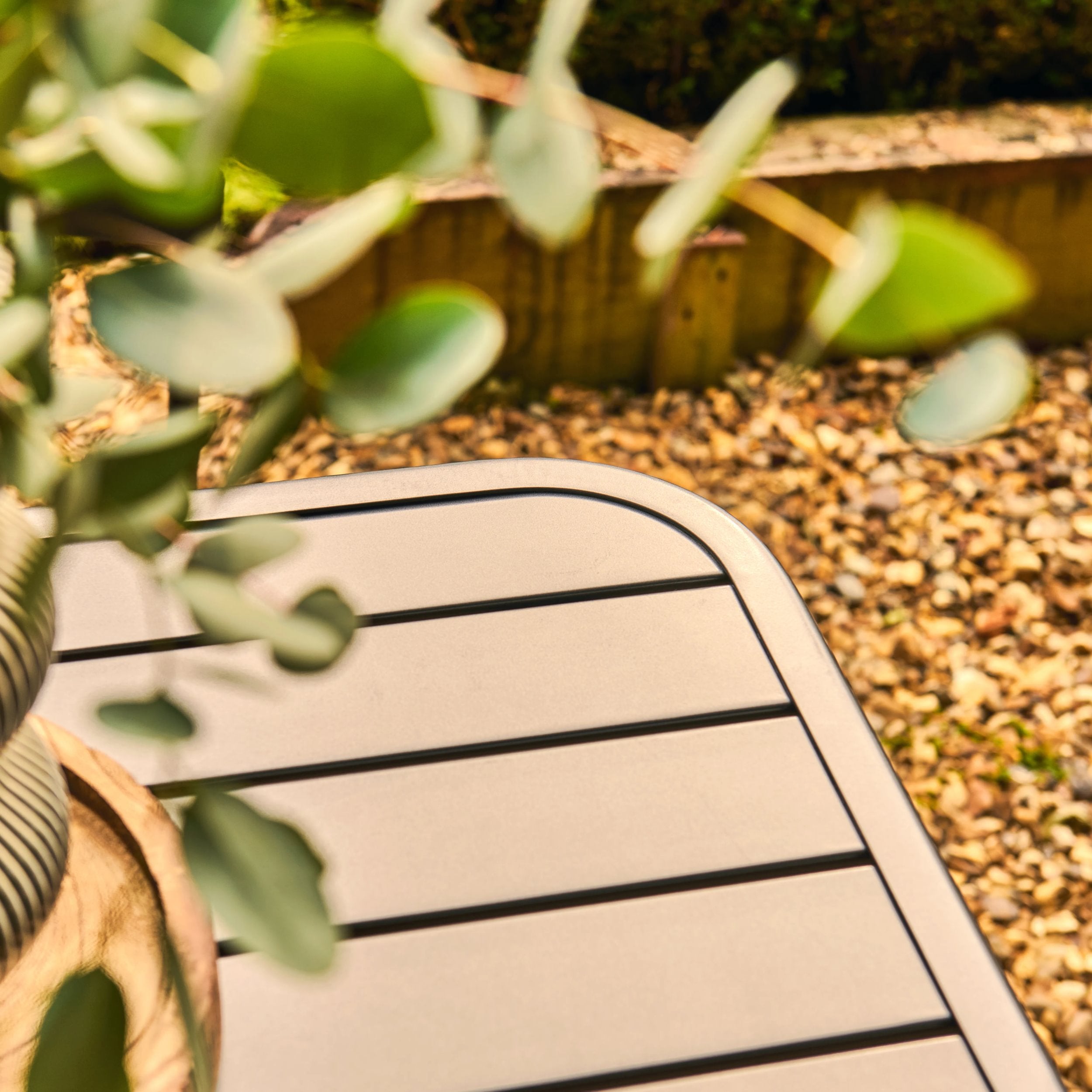 grey metal table with greenery in a garden setting