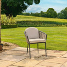 Chair with beige cushion on a patio in a garden setting