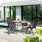 Outdoor patio set with table and chairs on a wooden deck.